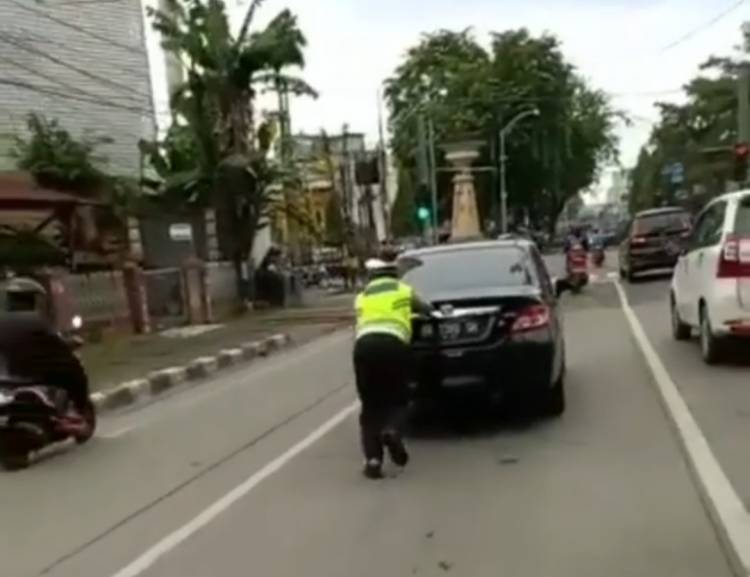 Personel Lantas Polsek Medan Kota Dorong Mobil Mogok